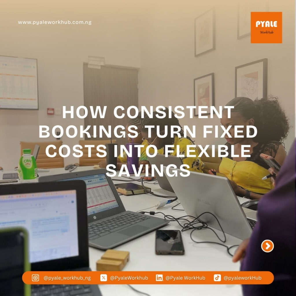 A group of professionals working on laptops around a large conference table at Pyale WorkHub.